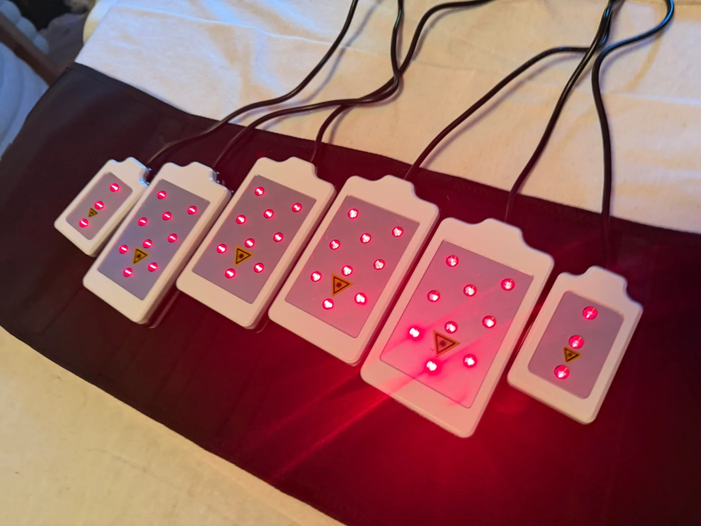Six illuminated laser lipo pads arranged on a treatment mat in the studio.